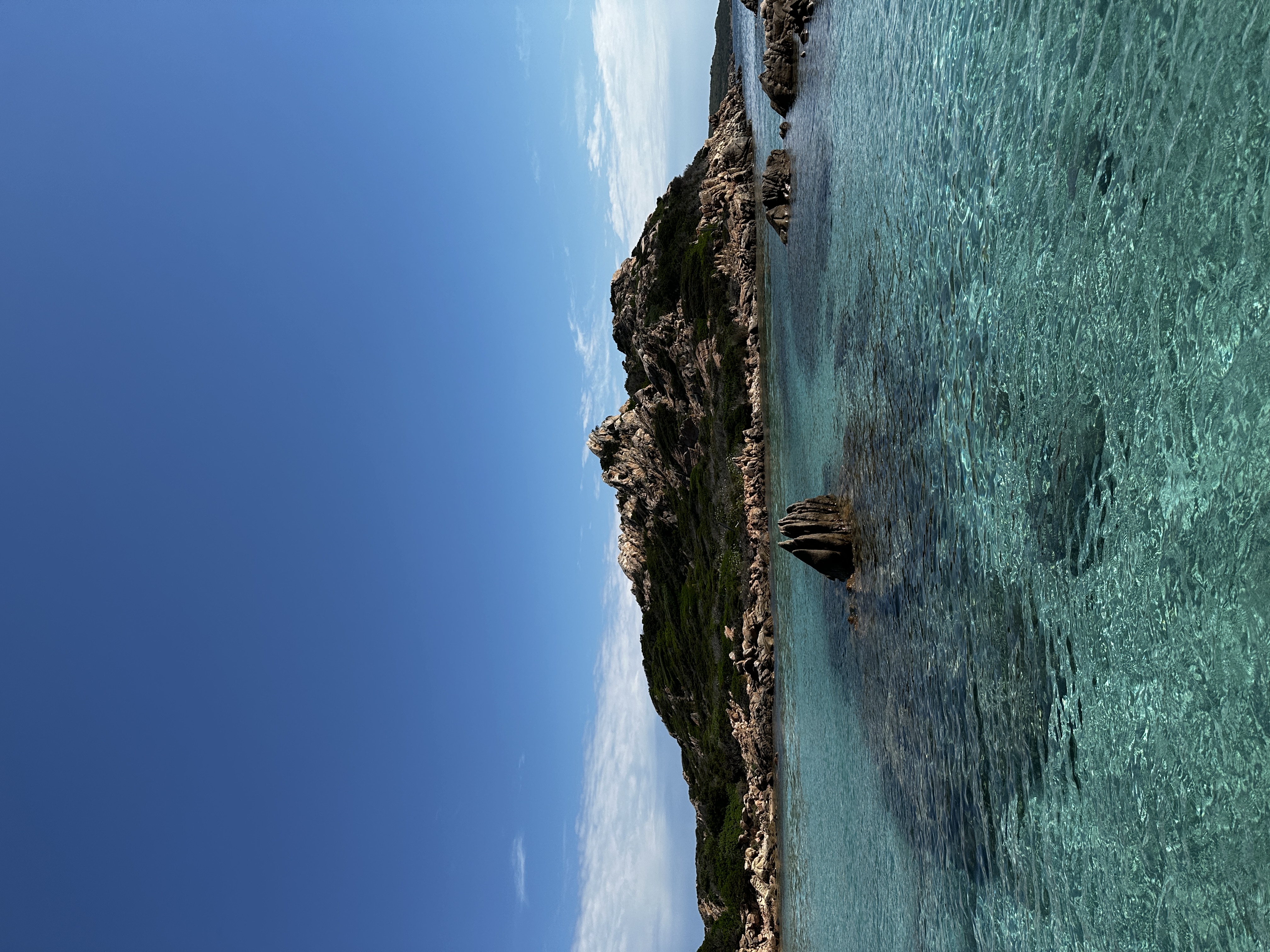 A coastal view with blue water and rocky islands